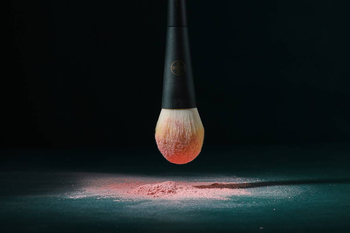 Professional makeup artist using a high-quality makeup application tool with tri-light settings for flawless blending